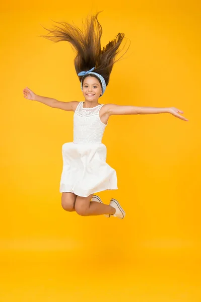 Jumping in mid air. Light and easy. Freedom. Kid full of energy jumping enjoy long healthy hair. Cute hairstyle. Happy childhood. Carefree baby. Beautiful hairstyle. Daily hairstyle for girls