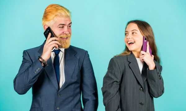 Buen trabajo. discusión de negocios. Un hombre de negocios habla por teléfono con una chica pequeña. Papá barbudo teñido de pelo. Chaqueta sobredimensionada para niños. Gente de negocios usando dispositivos. Equipo familiar exitoso. espíritu empresarial — Foto de Stock