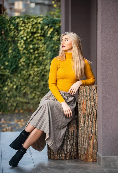 In her own style. must-have skirt. trendy girl wear corrugated skirt. pleated skirt collection. woman warm autumn skirt sit outdoor. relax while walking. enjoy casual day. Clothing features pleats