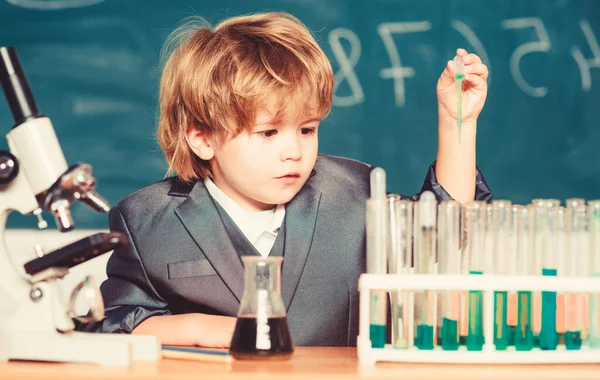 Erforschung biologischer Moleküle. Kleinkind Genie Baby. Junge in der Nähe von Mikroskop und Reagenzgläsern im Klassenzimmer. Technologie und Wissenschaftskonzept. Kinder studieren in der Schule Biologie und Chemie. Schulbildung — Stockfoto