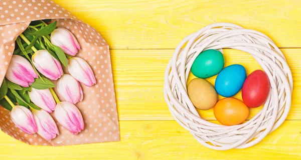 Bahar tatili. Gelenek Paskalya kutlamak. Mutlu Paskalya sezon. Paskalya yumurta sembolü. Bahar vibes. Paskalya geliyor. Top görünümünde renkli parlak yumurta ve buket taze Lale çiçek Sarı zemin üzerine — Stok fotoğraf