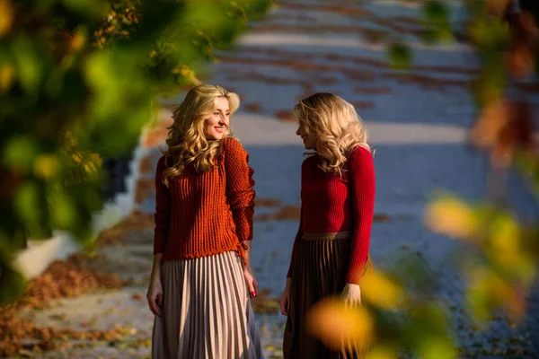 Femininity and tenderness. Women walking in autumn park. Pleated skirt fashion trend. Friends girls. Autumn stylish outfit. Fall fashion. Adorable ladies enjoy sunny autumn day. Fashionable clothes