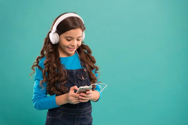 Online entertainment. Free music apps. Listen for free. Get music account subscription. Enjoy music concept. Enjoy perfect sound. Small girl child listen music modern headphones and smartphone