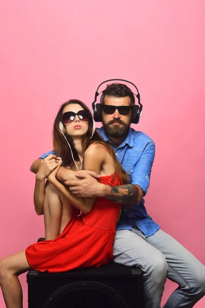 Guy with beard and lady hug and listen to music