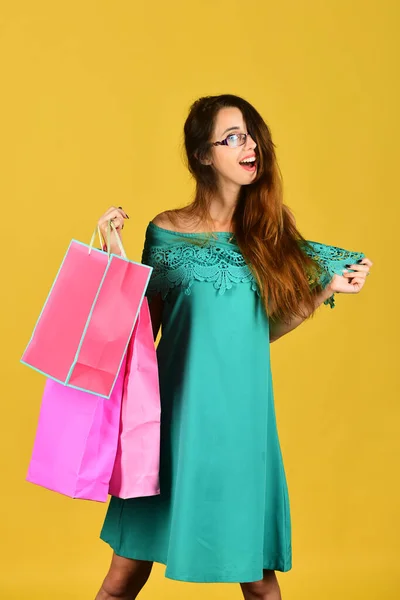 Concepto de compras y ocio. Señora de pie sobre fondo amarillo — Foto de Stock