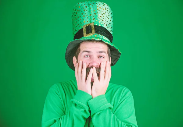 Ukrywszy twarz z rąk z radości. Szczęśliwy człowiek irlandzki z brodą, ubrany w zielony. Hipster w leprechaun kapelusz i strój. Happy saint Patryka. Brodaty mężczyzna obchodzi Dzień Świętego patricks — Zdjęcie stockowe