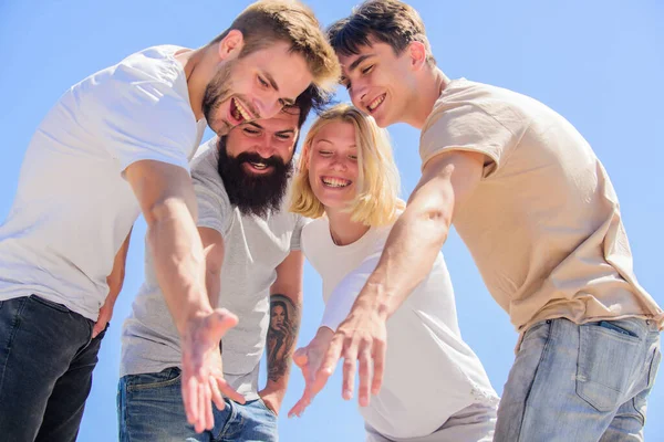 Reach out. Happiness in unity. Open mind for happiness. Carefree youth hang out together. See something adorable. Happiness. Group people excited look down. Woman and men happy sky background