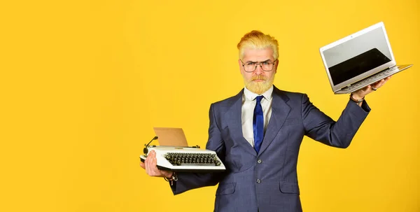 Moderno em vez desatualizado. Connoisseur de valores vintage. Máquina de escrever contra o portátil. O empresário usa a tecnologia moderna. Homem tingido barba cabelo amarelo fundo. Compre um novo gadget moderno. Dispositivo útil — Fotografia de Stock