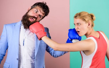 Sakallı hippi adam bir kadınla kavga ediyor. Güç ve güç. Nakavt yumruğu. ki o haklı. Dövüşü kazan. Aile boks eldivenleri. İlişki sorunları. Spor. Boks sporu konsepti