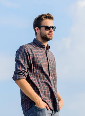 Ultraviyole koruma kavramı. Mükemmel görüş. Göz sağlığı. Modaya uygun güneş gözlükleri. Erkek gözlüklü model açık havada mavi gökyüzü arka planı. Yakışıklı adam güneş gözlüğü takıyor. Moda gözlüklü hippi.