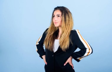 Zarif ve atletik parçaları karıştırıyorum. Spor kıyafetleri podyumlarda kural koyuyor. Voluminous kıvrımlı saç stili. Moda kıvrımlı saç stili. Şık spor. Mavi arka planda kadın saç stili. Moda eğilimi