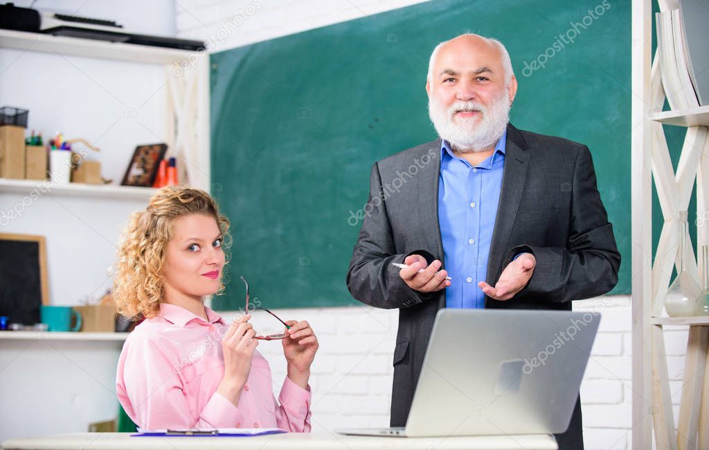 Communicate clearly and effectively. Lecturer educator sharing his knowledge. Work in education. Man mature school teacher and girl student with laptop. High school college university. Modern school