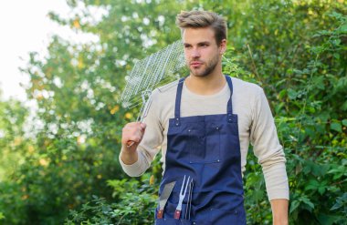 Parti devam ediyor. Açık havada et kızartmak için aletler. piknik malzemeleri. Hafta sonu dışarıda parti var. Aile hafta sonu gezisi. Yaz pikniği. Mutfak konsepti. Şef bbq yemeği pişiriyor. Man barbekü ızgarası