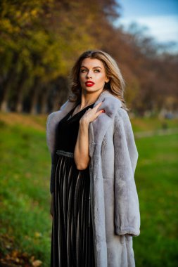 Daha akıllı ol. Çevre dostu. En lüks giysi malzemesi. Sokakta gezen modaya uygun bir bayan. rahat ve sıcak. Kıyafetini tamamla. Modern kış kürkü manto. Zarif kırmızı dudaklı kadın kürk giyiyor.