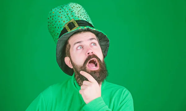 Estar perdido na contemplação. Hipster mantendo a boca aberta em chapéu de duende e traje. Homem barbudo a celebrar o dia dos santos padroeiros. Homem irlandês de barba verde. Feliz dia de santo patricks — Fotografia de Stock