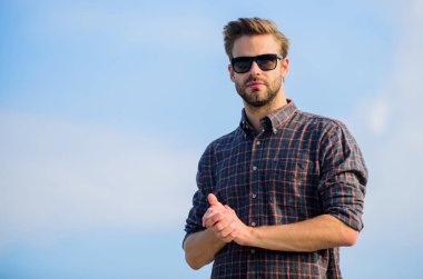 Erkek gözlüklü model açık havada mavi gökyüzü arka planı. Yakışıklı adam güneş gözlüğü takıyor. Moda güneş gözlüklü hippi. Ultraviyole koruma kavramı. Mükemmel görüş. Göz sağlığı. Moda güneş gözlüğü.