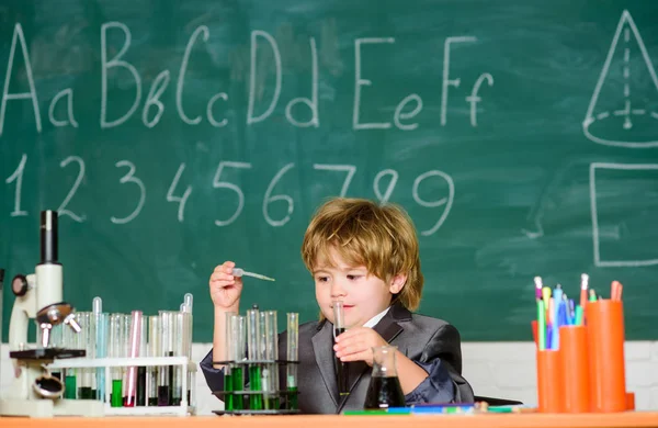 Grundläggande kunskaper i grundskolan. Ett pedagogiskt experiment. Pojkmikroskop och provrör i klassrummet. Kunskapskoncept. Fascinerande ämne. Kunskapsdagen. Kid studerar biologi kemi — Stockfoto