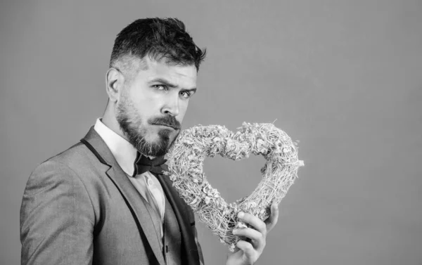 Man in love strict wear formal suit celebrate valetines day green background. Spread love around. Happy valentines day. Hipster hold heart symbol love. Bring love to family holiday. Romantic surprise — Stock Photo, Image