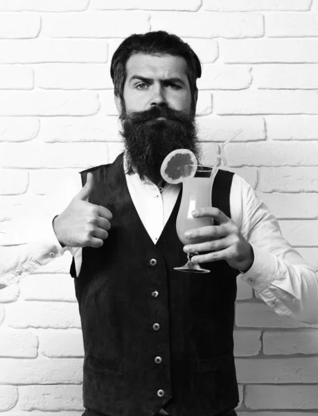 handsome bearded man with long beard on white brick wall studio background