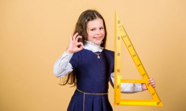 Büyük cetveli olan öğrenci kız. Okul öğrencisi geometri öğreniyor. Küçük kız okula geri döndü. BTMM okul disiplini. Matematik dersi. Eğitim ve bilgi. Okul müfredatı