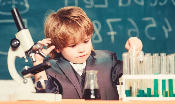 Chemische Analyse. Kleinkind Genie Baby. Wissenschaftskonzept. Hochbegabtes Kind und Wunderkind. Kind studiert Chemiestunde. Schulbildung. Junge benutzen Mikroskop und Reagenzgläser im Klassenzimmer — Stockfoto