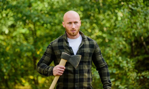 Un leñador calvo. Cosecha leña. Caminata de vacaciones. Caminata en el bosque. Cuidado del bosque. Determinación del espíritu humano. Hombre camisa a cuadros utilizar hacha. Brutal macho en el bosque. Potencia y fuerza. Lumberjack llevar hacha —  Fotos de Stock