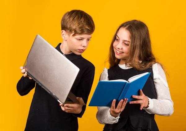 Tecnologia digital para aprendizagem. As crianças pequenas usam novas tecnologias na escola. Menina e menino segurar livro de TI e laptop. Tecnologia na educação. Tecnologia educacional. E-learning. Cursos online — Fotografia de Stock