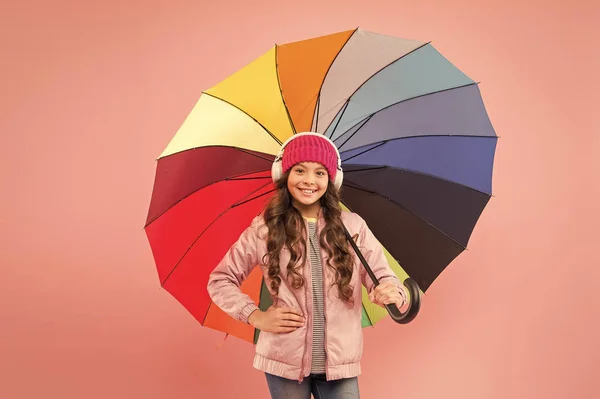 Cada día divertido. Niño disfrutando de cosas simples. Diviértete. Un concepto divertido. Me siento bien. Chica divirtiéndose caminando auriculares inalámbricos bajo paraguas colorido. Ocio de otoño. La música siempre conmigo — Foto de Stock