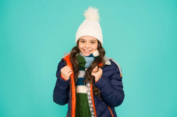 Kind draagt hoed en jasje blauwe achtergrond. Wintersport. Ik voel me op mijn gemak. Koud seizoen winkelen. Kind in gewatteerde warme jas. Seizoensgebonden mode. Wintervakantie. Mode meisje winterkleding. Modetrend — Stockfoto