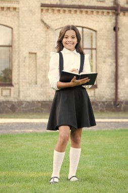 Anlayışlı okuyucular için bir ders. Mutlu liseli kız ders için notlar alıyor. Küçük çocuk okul dersi için hazırlan. Sevimli küçük kız elinde kalem ve ders kitabı tutuyor. Okul ve eğitim