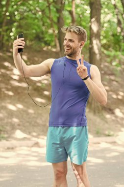 sağlıklı bir hayat. Spor giyim sektöründeki atletik adam selfie çekiyor. Açık hava antrenmanı. Fitness uygulaması. Ui ux kavramı. Modern sporda bir alet. İz sürücüdeki kaslı adam. Telefondaki spor uygulaması. Dijital spor. akıllı saat