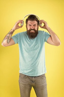 Korkunç bir ses. Hipster kırık kulaklıklar müzik Gadget dinle. Nefret dolu bir şarkı. Müzik tadı. Sakallı adam müzik sevmez. Rahatsız edici ses. Adam müzik kablosuz kulaklıklar dinlerken. Equalizer ayarları
