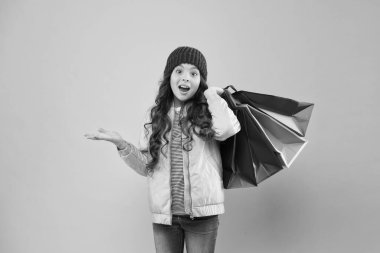 Satış ve indirimler. Mutlu çocuk. Yetenekli küçük kız. Kış alışverişi. Müşteri konsepti. Noel indirimi. Çocuk modası. Tatil alışverişi tasarrufu. Evden alışveriş. Alışveriş çantalı küçük kız.