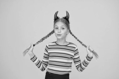 İçindeki küçük şeytan. Kızsal öfke. Şirin ama tehlikeli. Cadılar Bayramı konsepti Kırmızı boynuzlu küçük sevimli çocuk. Karnaval için aksesuarlar. Partiye hazırlanıyorum. Küçük şeytan. Oyuncu şeytan kız.