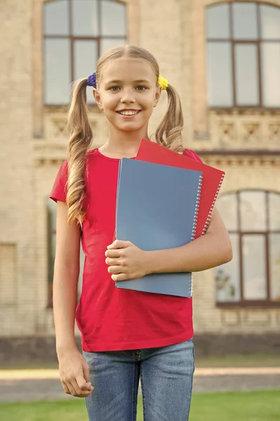 可爱的小书虫。可爱微笑的小孩子拿着书教育机构背景。可爱的小女孩学生。中学生。学习语言。学校教育理念 — 图库照片