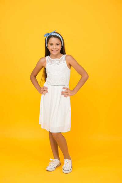 Не отставать от модных тенденций. Мода маленькая модель на желтом фоне. Счастливый ребенок наслаждается модой. Мода и стиль. Прелестная модница. Стиль и красота. Салон моды. Детский магазин