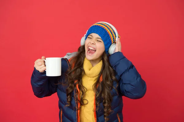 Music taste. Weekend begins like that. Hipster fashion trend. Winter holidays activity. Feeling warm and happy. Cheerful smiling child stylish outfit listen music. Listening music and drinking cocoa