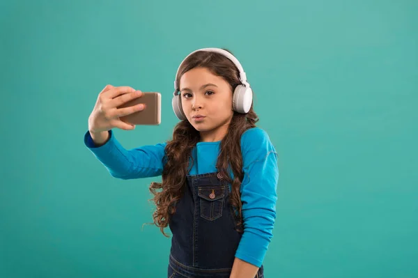 Czuję się zabawny i zabawny. mała rozmowa wideo dziecka na smartfonie. Mała dziewczynka trzyma telefon komórkowy. blogowanie we współczesnym życiu. Uczennica używa nowej technologii. żyć w wirtualnym świecie. selfie dziecko w słuchawkach — Zdjęcie stockowe