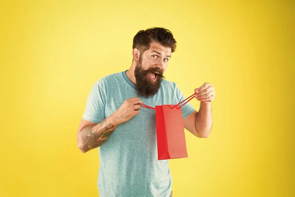 Feliz bolso de papel hipster hold. Hombre barbudo sonriendo con compra de moda. Compra de impulso. Concepto de compras. Tienda boutique centro comercial. Compra el producto. Diferencias de género en la toma de decisiones — Foto de Stock