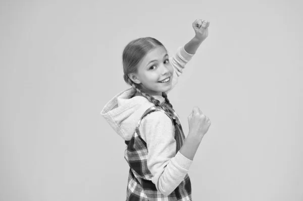 Stile casual. Felice giornata internazionale dei bambini. Sfondo giallo bambina. Idea di buon umore. Vibrazioni positive. Emozioni sincere. Bella ragazza intrecciata. Capelli lunghi. Piccola ragazza a scacchi camicia — Foto Stock