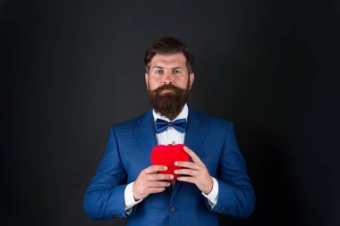 Sevgililer Günü. Yakışıklı sakallı adam smokin giyer. Romantizm ve flört. Centilmen romantik ruh. Adam sevginin kalp sembolünü taşıyor. Randevu servisi. Centilmen kavramı. Gerçek beyefendi.