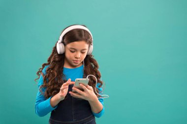 Liseli kız dijital cihaz kullanıyor. Çocuklar için sıradan moda. Uzun saçlı çocuk kulaklıkla müzik dinliyor. Küçük çocuk akıllı telefondan çalma listesi yapıyor. Küçük kız mp3 çalar kullanıyor. Modern hayatta okumak. Boşluğu kopyala