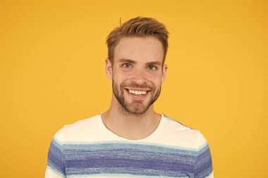 Olumlu duygular. Sarı arka plandaki mutlu adam. Sakallı adam gülümsüyor. Bıyıklı ve sakallı, mutlu yüz ifadesi olan adam. Mutluluk kavramı. Psikolojik sağlık. Mutlu duygusal adam yakın