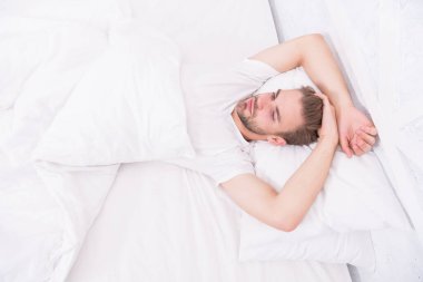 Sağlıklı uyku alışkanlıklarını destekleyen ipuçları. Yatakta dinlenen yakışıklı adam. Düzenli olarak geceleri uyuyun. Yatmadan önce meditasyon gibi sakinleştirici aktiviteler üzerinde çalış. Sağlıklı uyku konsepti