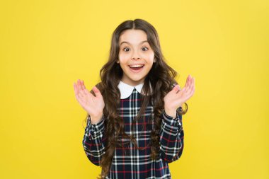 Harika haberlerim var. Mutlu gülümseyen çocuk portresi. Duygusal ifadeler. Sadece mutluyum. Küçük kız zarif damalı elbise. Çocuk uzun kıvırcık saçlı. Mutlu liseli kız üniforması. Çocukluk kavramı