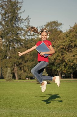 Öğrenmenin keyfi. Eğlenmene bak. İyi çalışmalar. Müzik dinleyen kız, modern alet. Okul kitaplarıyla çalışan mutlu kulaklıklar. Stereo kulaklık. Çocuk modern teknolojiyi kullanıyor. Modern okul kızı
