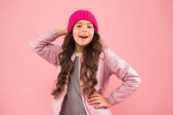 Activités hivernales. petite fille veste gonflante et chapeau tricoté. soins de santé par temps froid. bonne humeur par tous les temps. enfant en vêtements chauds d'hiver. mode saisonnière pour les enfants. petite beauté mur rose — Photo