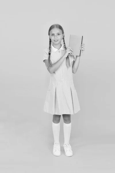 Diary for girls concept. happy little girl in retro uniform. vintage kid fashion. back to school. girl hold workbook or notepad. encyclopedia book for children. small girl love literature. old school — Stock Photo, Image