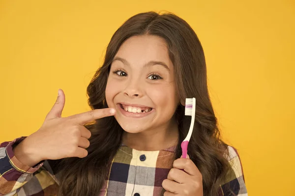 Έβγαλε το δόντι της. Ευτυχισμένο παιδί δείχνουν δόντι γάλα αφαιρεθεί. Μικρό κορίτσι με ανοιχτό στόμα και οδοντόβουρτσα. Η νεράιδα των δοντιών θα την επισκεφτεί. — Φωτογραφία Αρχείου