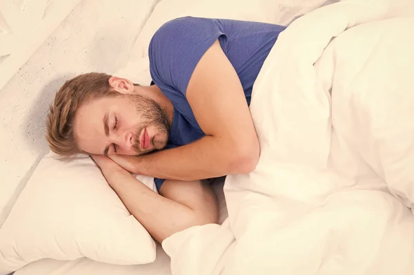 Duerme lo suficiente cada noche. Hombre barbudo durmiendo cara relajante. Mantener un ritmo circadiano consistente es esencial para la salud general. Un hombre guapo durmiendo. Consejos para dormir mejor — Foto de Stock